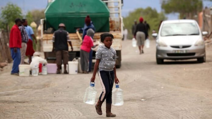 Township residents carry bottles collected from a municipal water tanker in drought-stricken Graaff-Reinet, South Africa, November 17, 2019. File Image/Reuters